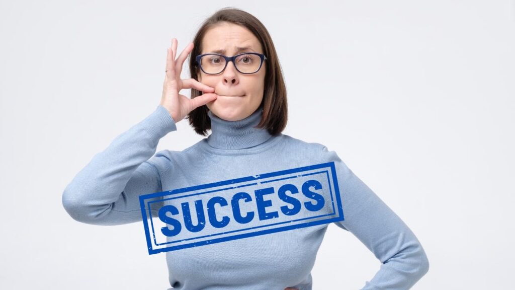 Mulher de óculos faz sinal de silêncio com a mão enquanto veste suéter azul claro; ao centro, a palavra “SUCCESS” em destaque, representando o que as pessoas mais bem-sucedidas fazem.